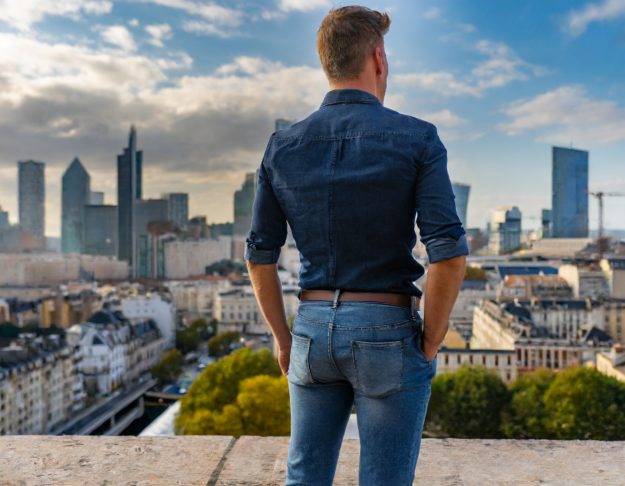 Un homme portant un jean bleu foncé de forme tapered dans un paysage urbain 31388
